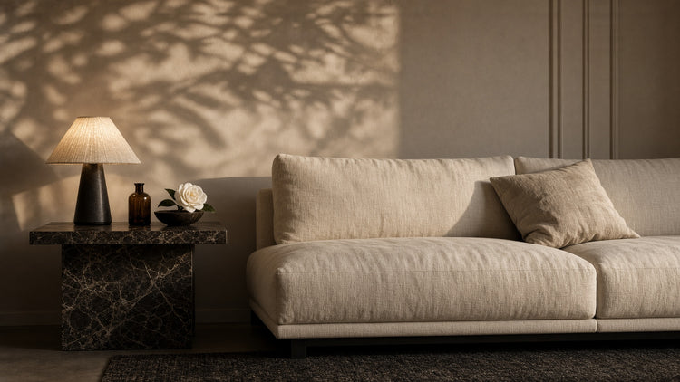 A linen sofa beside a lamp and an amber bottle at home